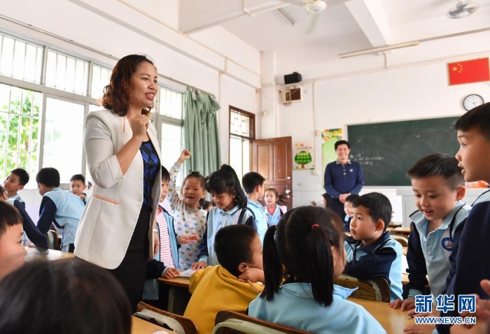 2019年2月20日，米雪梅（左）在中山市沙溪镇虎逊小学调研时与小学生交流。新华社记者 刘大伟 摄