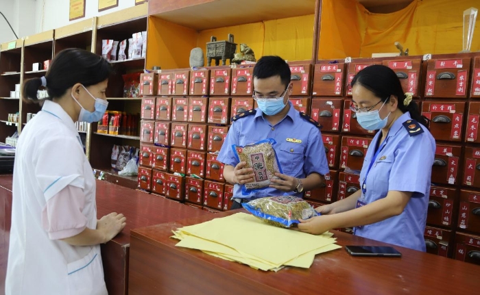 图为该局执法人员在一家药店检查中药饮片。