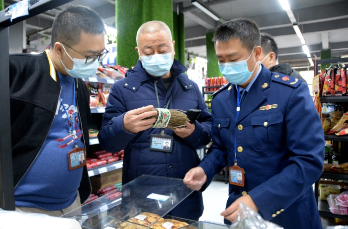 图为执法人员在一家超市检查红苕粉的标签标注情况。