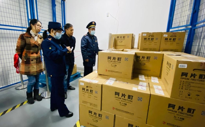 图为执法人员对药品生产企业生产过程中使用的麻醉药品使用记录进行检查。