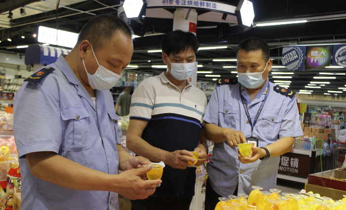 图为5月30日，尉氏县市场监管局执法人员在一家超市检查儿童食品标签标识。