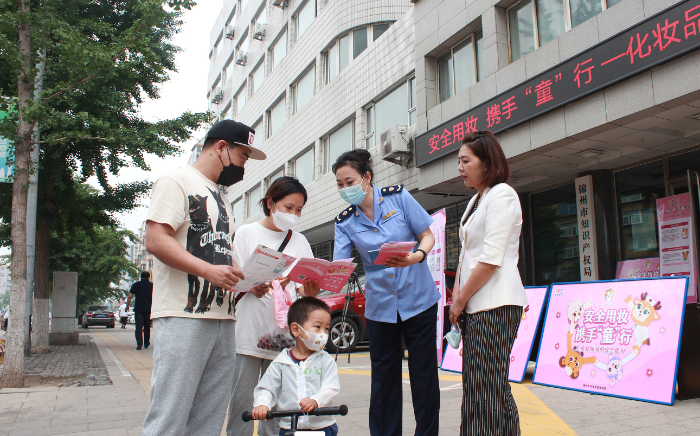 图为锦州市市场监管局执法人员在活动现场向公众普及儿童化妆品安全知识。