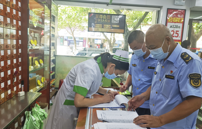 图为集美区市场监管局执法人员在一家药店检查“四类药品”购药登记情况。