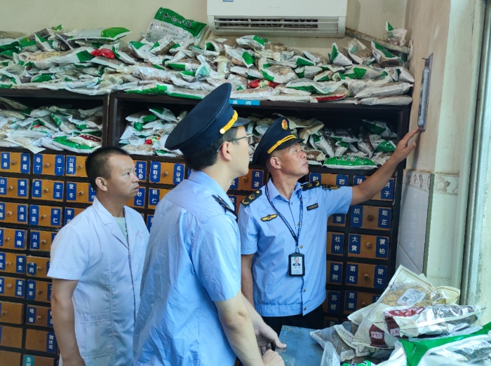 图为该局执法人员在一家零售药店检查中药饮片储存环境温湿度。（鄢国卿 摄）