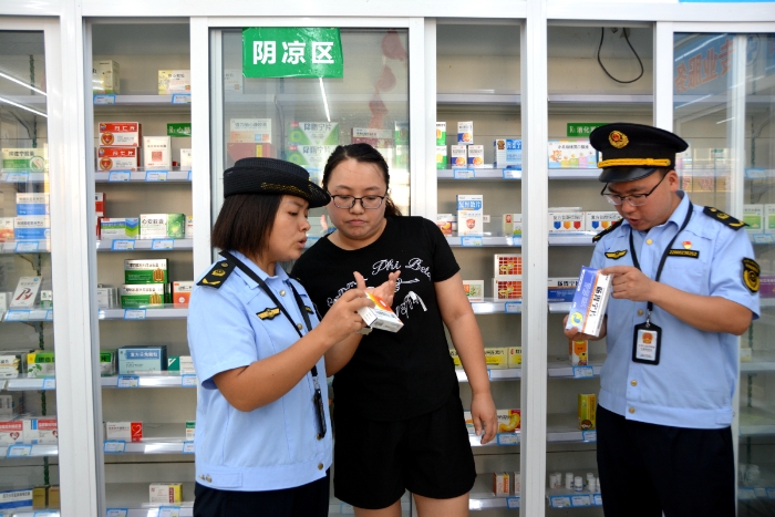 图为8月23日，该局青羊镇市场监管所执法人员在一家零售药店检查阴凉药品存储情况。