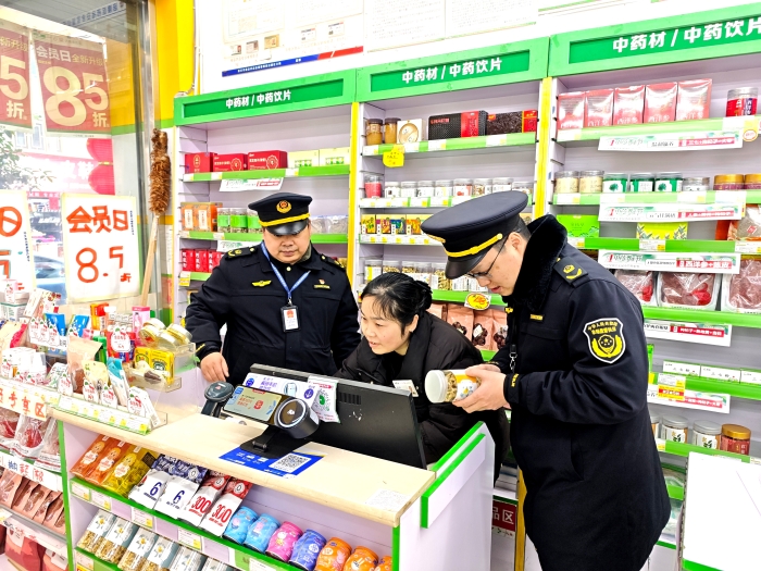 图为该局监管人员在一家药店检查中药饮片的进货来源和销售记录