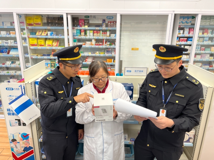 图为该局执法人员在一家药店核查常用医疗器械外包装上标示的相关信息。（孙建新 摄）