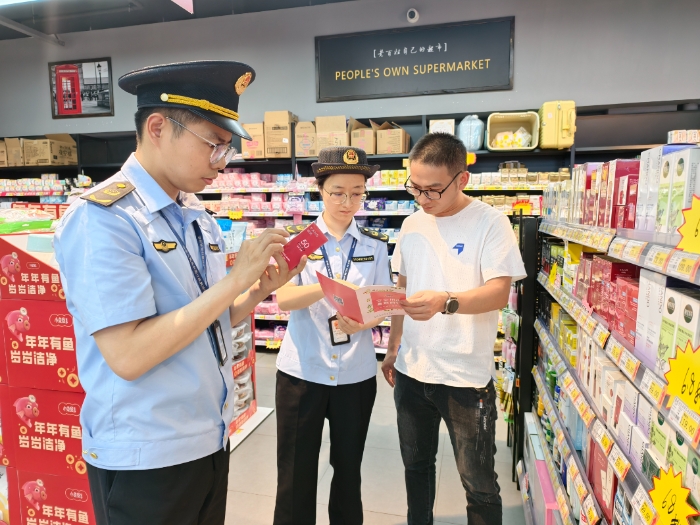 图为该局执法人员在一家商超内对其经销的防晒化妆品外包装上标注的相关信息进行仔细核查。（李瑶 孙建新 摄）