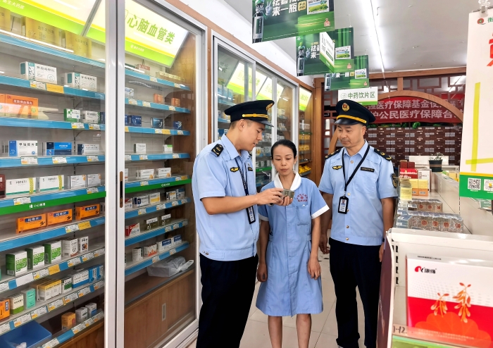 图为该局执法人员在一家药店通过检查药品的外包装核查药品质量。（胡瑞 文光辉 摄）